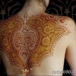 Фото тату мехенди на спине девушки. Детализированный узор, выполненный в технике росписи хной, украшен сверкающими кристаллами.