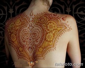 Фото тату мехенди на спине девушки. Детализированный узор, выполненный в технике росписи хной, украшен сверкающими кристаллами.