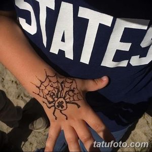 Фото тату хной: паук в паутине на руке ребенка, выполненный в коричневых тонах, милый и безопасный рисунок.