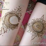 Фото тату: симметричные рисунки хной на ногах, изображающие луну и солнце с завитками и узорами, выполненные в коричневых тонах.