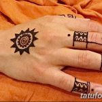 Фото хенны: рисунок солнца на тыльной стороне руки с геометрическими узорами и волнистыми линиями на пальцах.