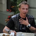 Фотография Михаила Горшенёва с татуировками на руках, демонстрирующая его бунтарский образ и любовь к рок-культуре.