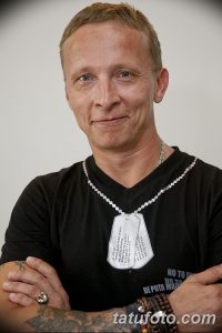 Фотография Игоря Талькова в черной рубашке, с татуировками на руках и на шее, с серьгами и цепочкой.