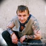 Фотография Игоря Талькова, сидящего на фоне стены, с татуировками на руках и груди.