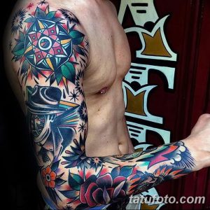 Фото тату на руке: рукав, выполненный в стиле олдскул, с изображением различных символов, таких как цветы, животные и геометрические фигуры.
