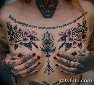 Фото тату на груди: розы, стрелы и надпись "Begin by changing in you what you want to see changed around us" в стиле олд скул.