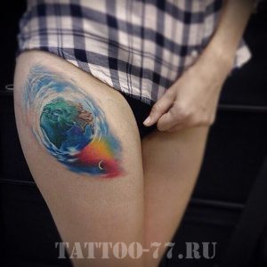 Фото тату на бедре: акварельное изображение Земли, окруженной океаном и луной. Яркий и оригинальный рисунок татуировки.