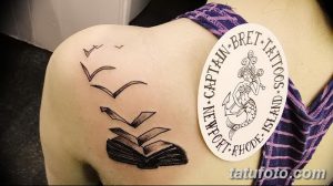 Фото тату на плече с изображением открытой книги, из которой вылетают птицы, выполненной в черно-белом стиле с детальной проработкой.