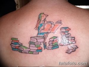 Фото тату на спине: девочка, сидящая на стопке книг и читающая другую книгу. Яркие цвета и мультяшный стиль.