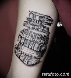Фото тату на руке: стопка книг, выполненная в реалистичном стиле. Детализированный рисунок татуировки с названиями книг.