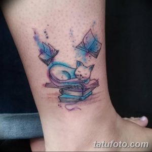 Фото акварельной татуировки на лодыжке, изображающей спящего кота на стопке книг. Нежные цвета и милый сюжет создают уютную атмосферу.