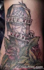 Фото татуировки на руке с изображением гроба, украшенного розой, и надписью 'True Til Death'. Черно-красный рисунок татуировки.
