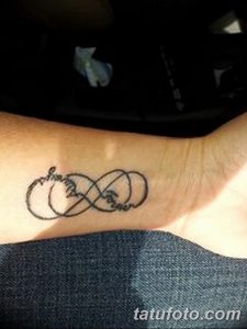 Фотография татуировки бесконечности с надписью "Forever" на запястье. Черный рисунок на светлой коже. Романтичный и символичный дизайн.