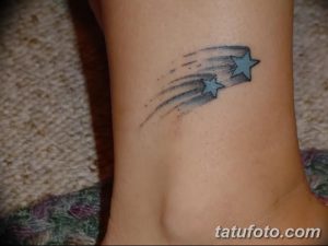 Фото тату: падающая звезда с хвостом на лодыжке. Нежный рисунок татуировки в акварельном стиле, выполненный в голубых и серых тонах.