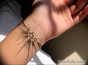 Фотография татуировки на запястье, изображающей звезду, состоящую из тонких линий, расходящихся в разные стороны. Дизайн выполнен в технике лайнуорк.