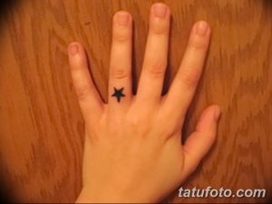 Фото татуировки с одной маленькой звездой на пальце руки. Тату выполнено в черном цвете и имеет простой дизайн.