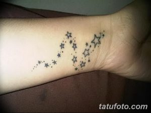 Фото минималистичной татуировки на запястье: цепочка из маленьких звезд разного размера. Тонкие линии, нежный дизайн.