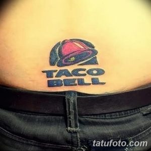 Фото тату: цветной рисунок логотипа сети быстрого питания Taco Bell, расположенный на животе человека, выполненный в простом стиле.