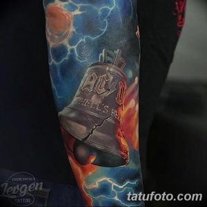 Фото тату колокольчика AC/DC с трещинами и эффектом разрушения. Реализм, яркие цвета, огонь и молнии.