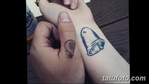 Фото парной татуировки, изображающей половинки сердца на руках двух людей. Символ любви и единства, выполненный в черном цвете.