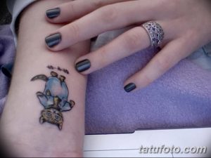 Фото тату маленького котенка, перевернутого головой вниз, с подписью на запястье. Нежный рисунок татуировки для любителей кошек.