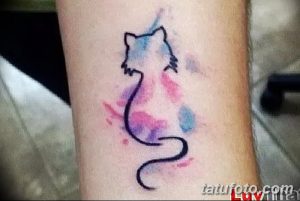 Фото тату: минималистичная акварельная татуировка кошки на внутренней стороне предплечья. Изображение выполнено в нежных пастельных тонах.