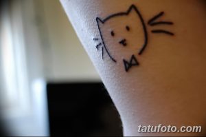 Фото минималистичной татуировки кошки на руке. Тонкие линии, простой дизайн, лаконичный образ. Идеально для любителей минимализма.