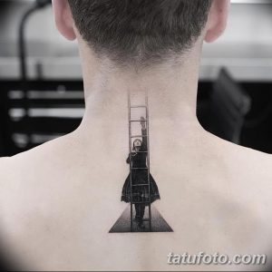 Черно-белое фото татуировки на спине, изображающей девочку, стоящую на лестнице, уходящей в перспективу. Минималистичный стиль, акцент на тени.