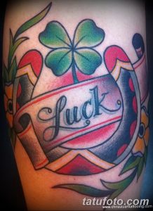 Фотография татуировки с изображением четырехлистного клевера и надписи 'Luck'. Яркие цвета, традиционный стиль. Символ удачи и везения.