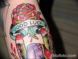 Фото тату розы с надписью "Good Luck" в стиле олд скул. Рисунок выполнен в ярких цветах с использованием черного контура.