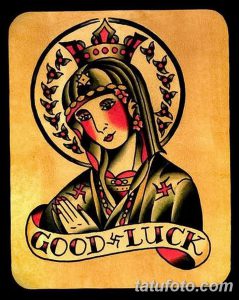 Фото тату Девы Марии в стиле олд скул с надписью "Good Luck". Рисунок выполнен в черном, красном и белом цветах.