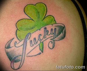 Фото минималистичного тату четырехлистного клевера с надписью "Lucky". Рисунок выполнен в зеленых и синих тонах.