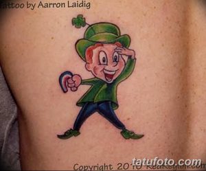 Фото мультяшной татуировки лепрекона с клевером в руке. Яркие цвета, забавный стиль.