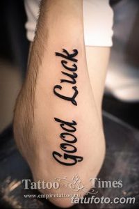 Фото татуировки надписью 'Good Luck' на руке. Черный цвет, каллиграфический шрифт.