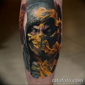 Фото тату Скорпиона из Mortal Kombat на ноге, выполненное в гиперреалистичном стиле с яркими цветами, детальной проработкой маски и языками пламени.