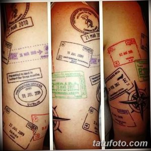 Фото тату, изображающее множество отпечатков штампов из разных стран и компас на руке. Детализированный рисунок татуировки, символизирующий любовь к путешествиям и приключениям.