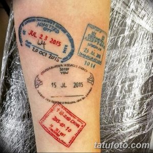 Фото тату, изображающее множество реалистичных отпечатков штампов из разных стран на руке. Детализированный рисунок татуировки, символизирующий страсть к путешествиям.