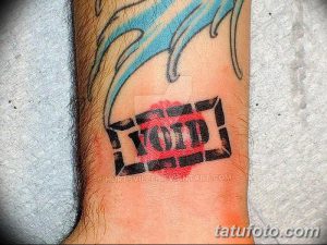 Фото тату на предплечье: надпись 'VOID' в черном прямоугольнике, словно отпечатанная помадой. Оригинальный и необычный рисунок татуировки.