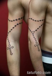 Фото парных татуировок четки на руках. Черно-серый рисунок татуировки, выполненный в реалистичном стиле, с детальной проработкой бусин и крестов.