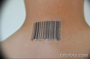 Фото татуировки штрих-кода с надписью 'OBEY CONFORM CONSUME REPEAT' на задней части шеи. Черный рисунок татуировки на светлой коже.