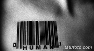 Фото минималистичного тату штрихкода с надписью 'HUMAN' под ним. Черно-белый рисунок татуировки на коже.