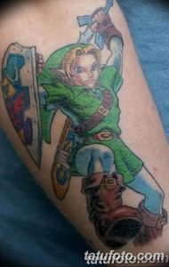 Фото тату персонажа Линк из игры The Legend of Zelda на предплечье, выполненное в ярких цветах с использованием зеленого, синего и коричневого.