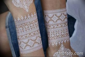 Фото белых татуировок хной на ногах двух девушек. Сложные восточные узоры, покрывающие голени.