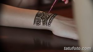 Фото тату хной: мастер наносит узор на запястье, демонстрируя детализированную работу и традиционный стиль.