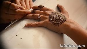 Фото тату хной на руке: сложный круглый узор с тонкими линиями и деталями, наносится опытным мастером.
