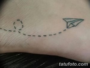 Небольшая татуировка на стопе, изображающая бумажный самолетик, летящий к облаку, соединенные пунктирной линией. Милый и символичный рисунок.
