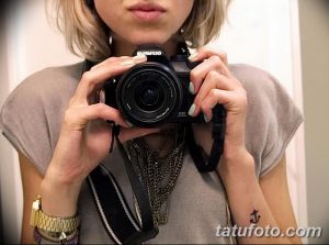 Фото маленькой татуировки в виде якоря на запястье. Черно-белый рисунок татуировки, выполненный в классическом стиле.