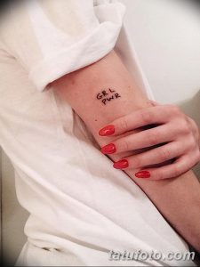 Фото тату надписи "GRL PWR" на руке. Рисунок выполнен черным цветом простым шрифтом.