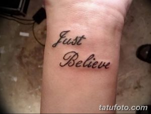 Фото тату с надписью "Just Believe", выполненной каллиграфическим шрифтом на запястье. Черно-белая татуировка с четкими линиями и изящным написанием.
