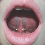 Фото пирсинга языка с необычным расположением украшений. Крупный план демонстрирует оригинальный дизайн и особенности ухода.